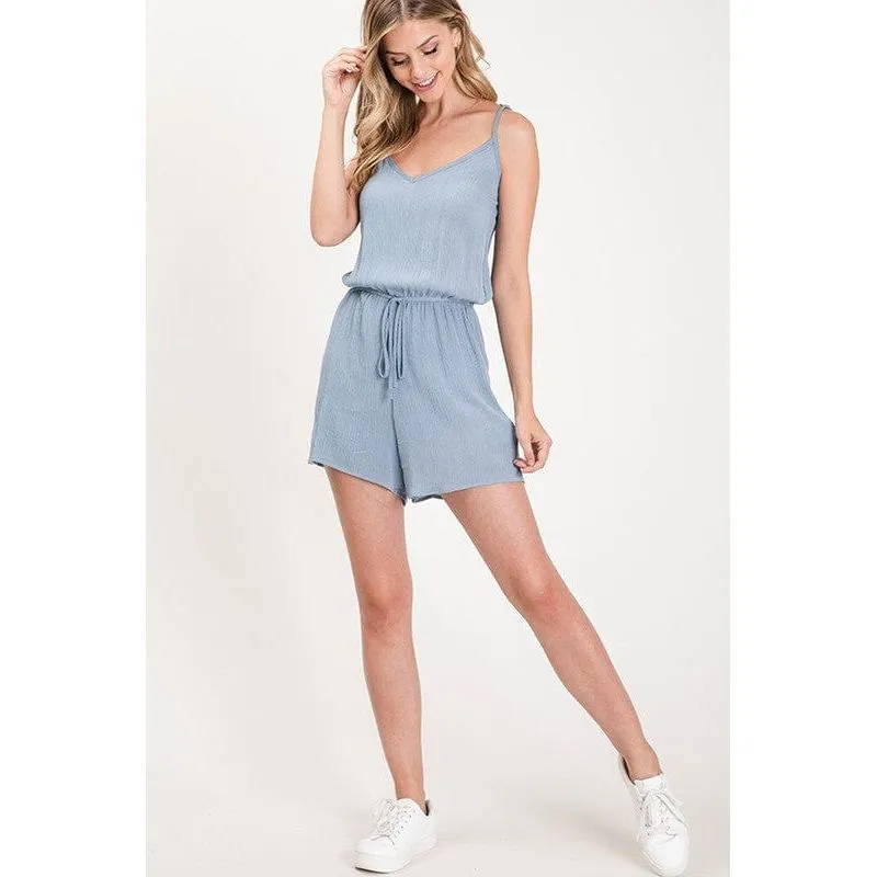 Textured solid color spaghetti strap jumpsuit with drawstring waist.
