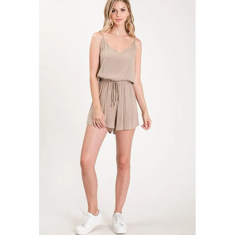 Textured solid color spaghetti strap jumpsuit with drawstring waist.